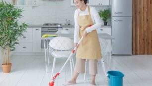 フローリングをワイパーで掃除する女性