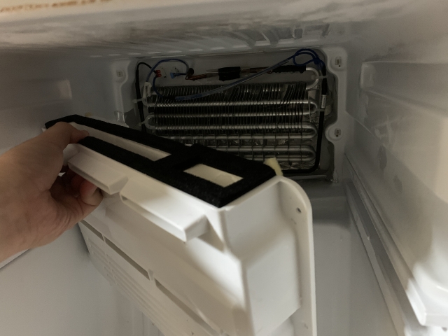 冷蔵庫のドレンホースの掃除の仕方を調べるシーン