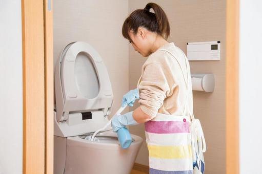 トイレ掃除ブラシを使う女性