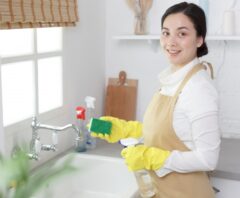 キッチンの油汚れを掃除しようとしている女性