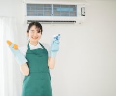 酸っぱい臭いがするエアコンの掃除方法を説明する女性