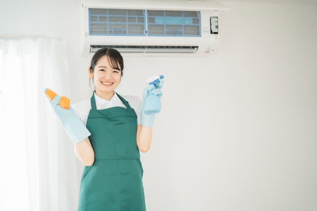 酸っぱい臭いがするエアコンの掃除方法を説明する女性