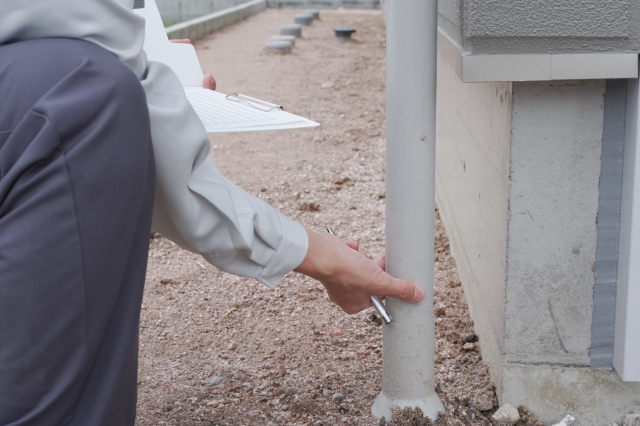 雨樋掃除の料金を見積る作業員