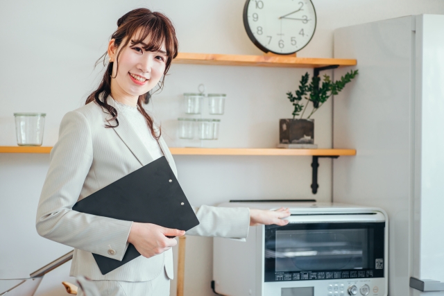 引っ越し時に電子レンジ/オーブンレンジの梱包方法を調べる女性