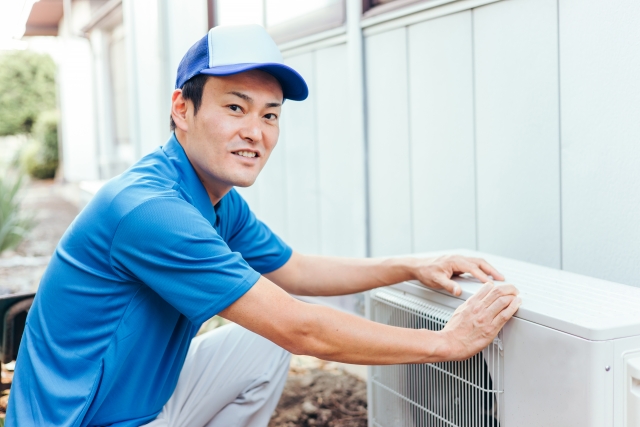 室外機を洗浄する男性