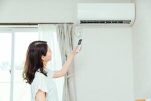 シーズン初めにエアコンをつける女性