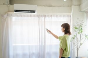 エアコンの臭いを30度と16度どちらで取ろうか迷っている女性