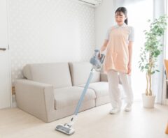 リビングで掃除機をかけて部屋を清潔に保つ女性