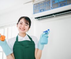 エアコンの清掃をしている笑顔の女性作業員