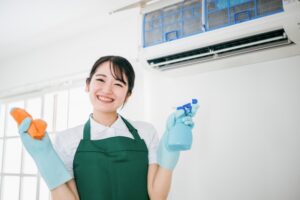 エアコンの清掃をしている笑顔の女性作業員