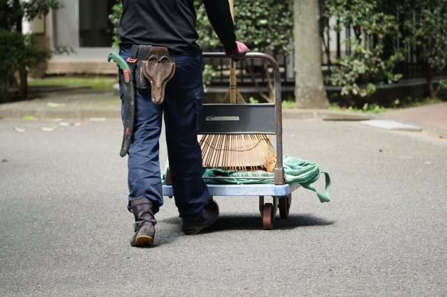剪定道具を台車で運ぶ作業員の後ろ姿