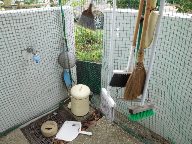 屋外の水まわり（洗濯機置き場）を清掃している様子