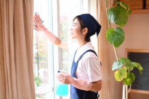 窓を掃除する女性の後ろ姿