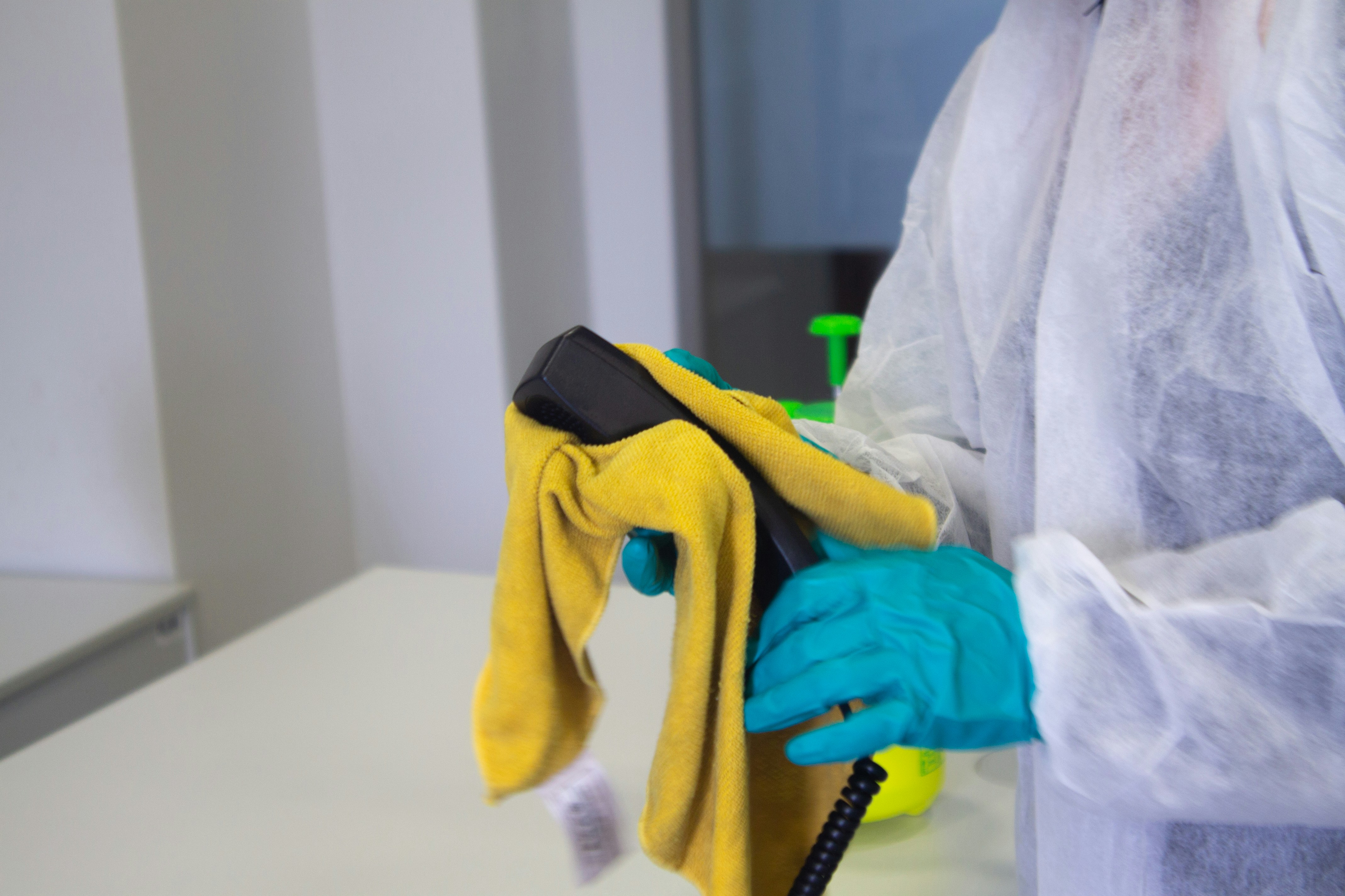 掃除用具を持った人がカビを拭き取っている様子