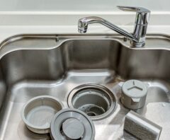 シンクの中に外した排水トラップ部品が並ぶ様子