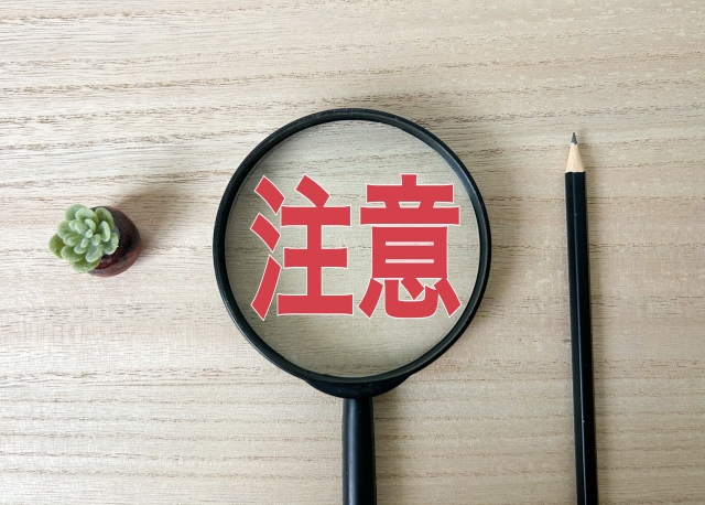「注意」の文字が拡大された虫眼鏡
