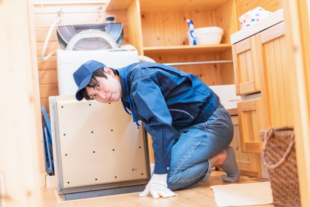 家具の下を確認する作業員