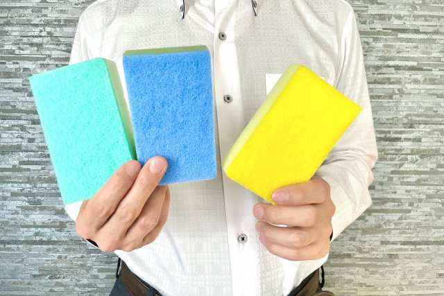 3色の掃除用スポンジを持つ人物の手元アップ