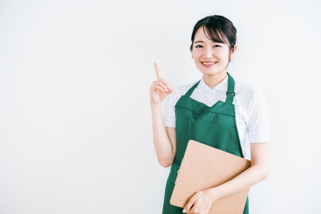 クリーニング業者の女性が親指を立ててポーズを取っている様子