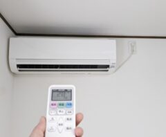 リモコンでエアコンの電源を操作している様子