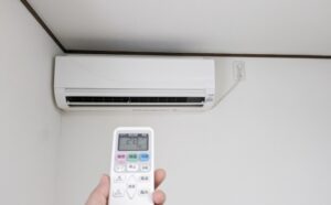リモコンでエアコンの電源を操作している様子