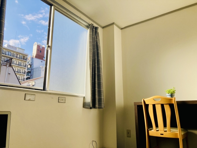 開け放たれた二階の窓と机のある室内風景