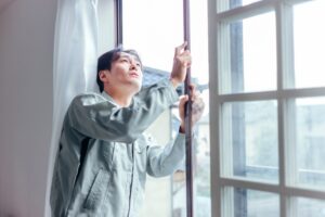 届かない窓の外側を掃除したいと思っている男性