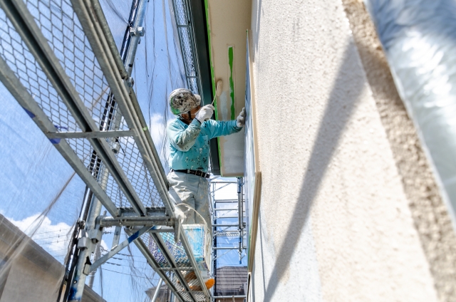 費用をかけて二階建てに設置した足場を使い、作業する人