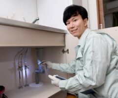 キッチンの排水口を点検する作業員