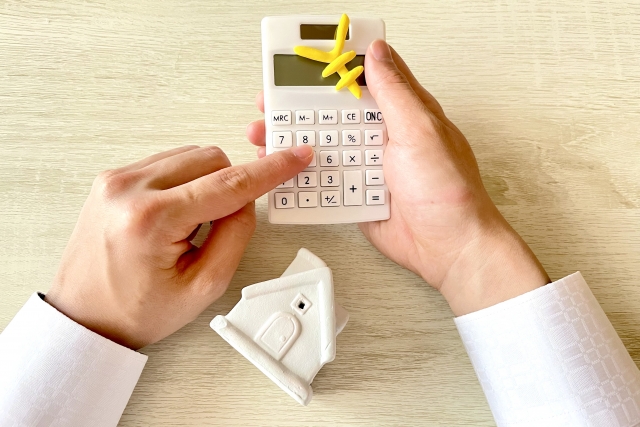 二階建てのの足場費用を計算する人の手