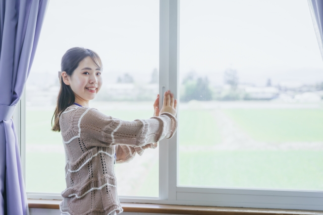 空間の除菌とあわせて換気をする女性