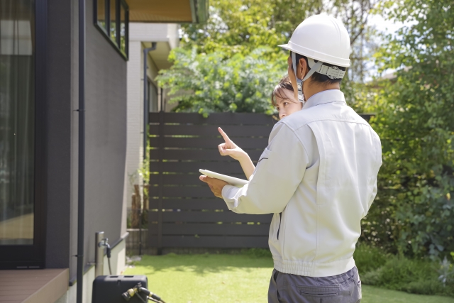 外壁を点検する作業員の後ろ姿