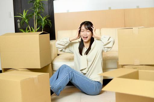 引っ越しの荷物が多いためどうするか悩む女性