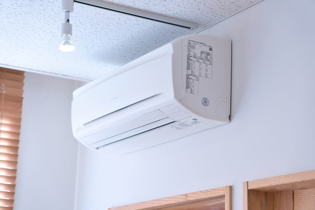 ゴキブリが落ちてきたエアコンの電源を切っている様子