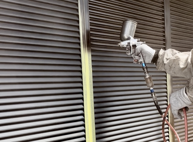 外壁塗装とあわせて雨戸も塗装しているスタッフの手