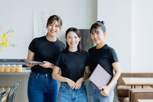 飲食店の制服を着た3人のスタッフが並んで立っている様子