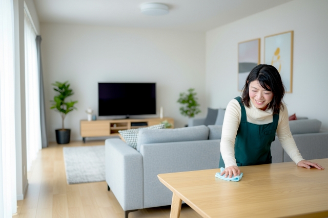 リビングのテーブルを布で拭き掃除している女性