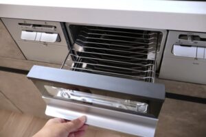 引き出し式の魚焼きグリルを開けて内部を確認している様子