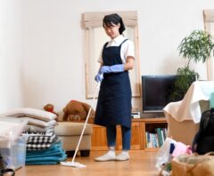リビングで床掃除をしているエプロン姿の女性