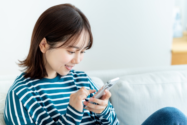 カーテンの引っ越しについて調べる女性