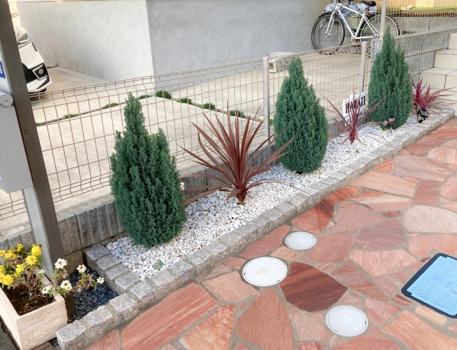 砂利敷きの花壇に並ぶコニファーと植栽