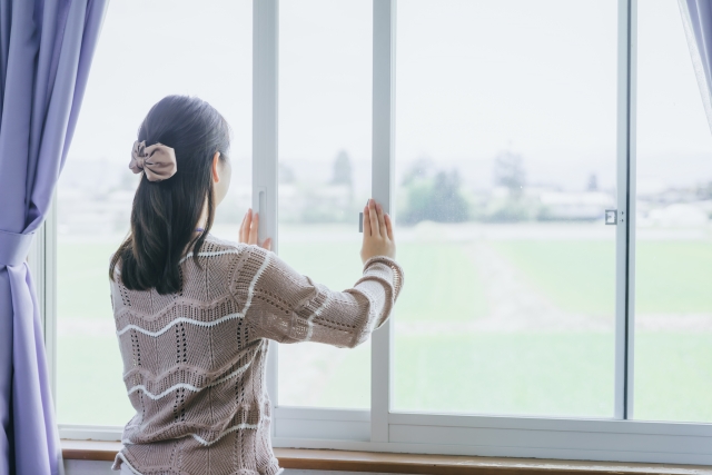 冬のゴキブリ対策で窓を開けて換気する女性
