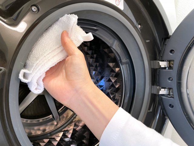 窓パッキンを拭く女性